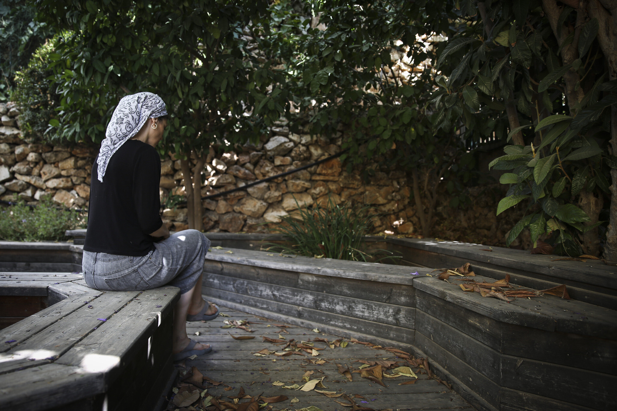 Orthodox Jewish woman sitting in a garden of a women's shelter for domestic violence